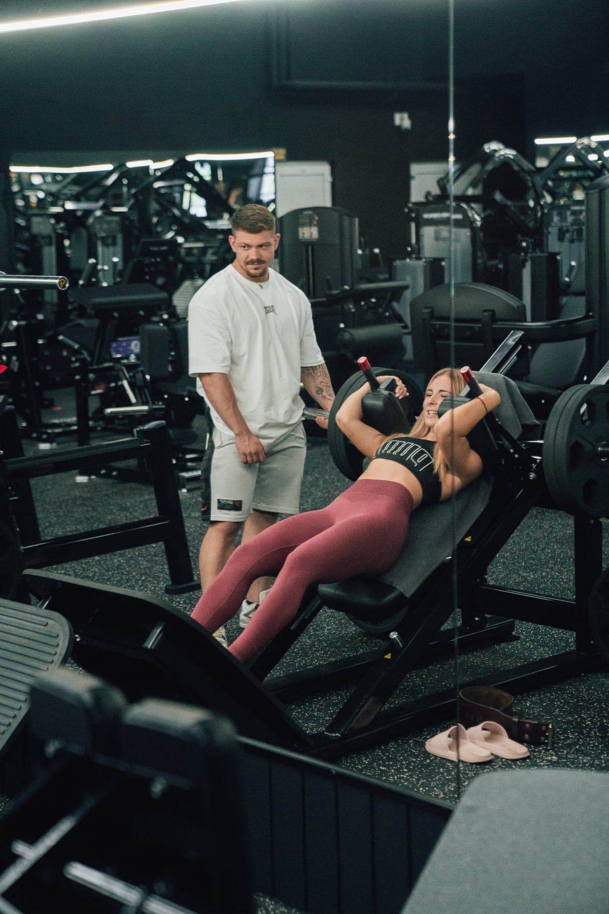 Osobný tréner koučuje klientku pri cviku v aréne Gladiator Gym